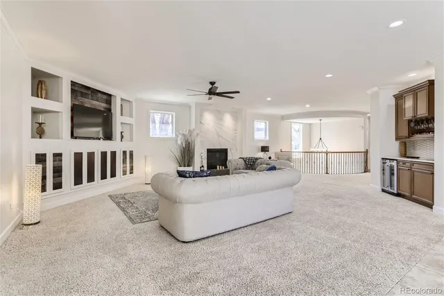 a living room with furniture a flat screen tv and a kitchen