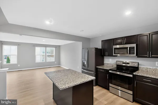 a kitchen with stainless steel appliances granite countertop a stove refrigerator and microwave