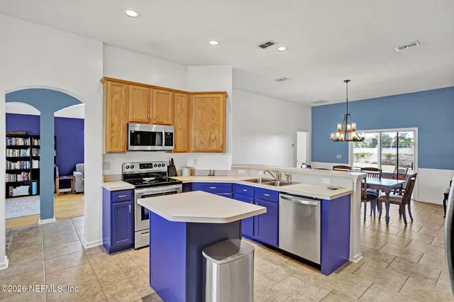 a kitchen with a stove top oven a sink a dining table and chairs