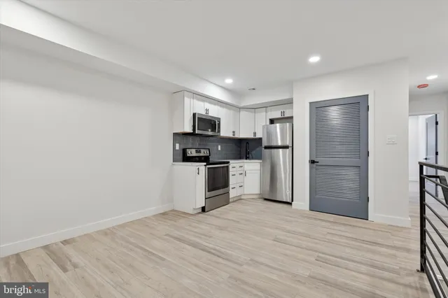 a kitchen with stainless steel appliances a refrigerator and a stove top oven