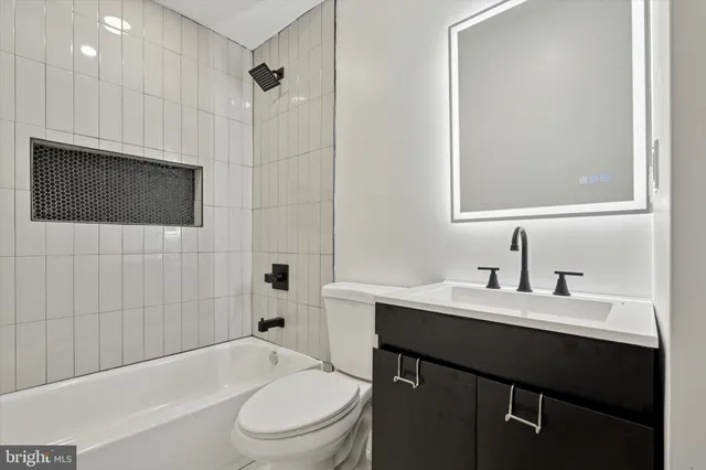 a bathroom with a sink a toilet a mirror and shower