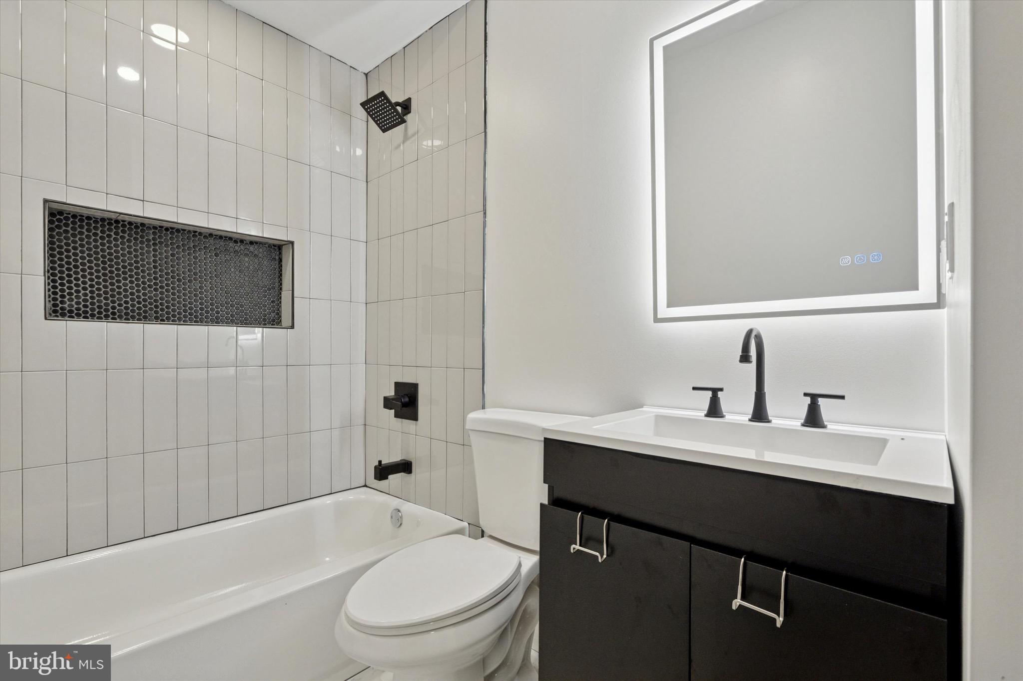 944 West Lycoming Street, Unit B Philadelphia, PA 19140 - Photo 4 of 8 a bathroom with a sink a toilet a mirror and shower