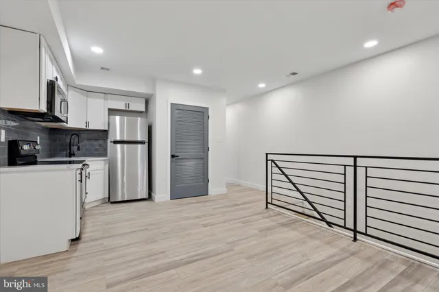 a kitchen with stainless steel appliances a refrigerator and a stove top oven