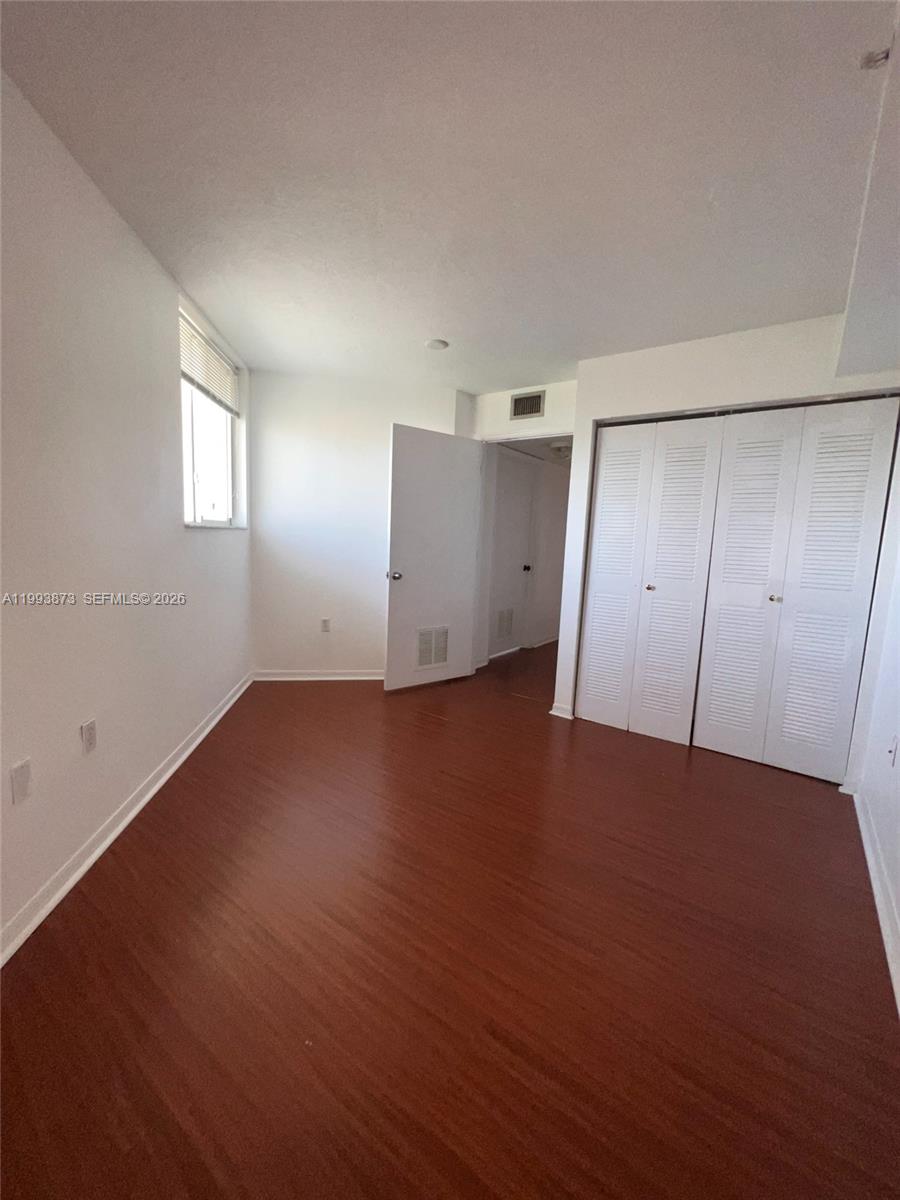 102 Southwest 6th Avenue, Unit 508 Miami, FL 33130 - Photo 20 of 27 an empty room with wooden floor and windows