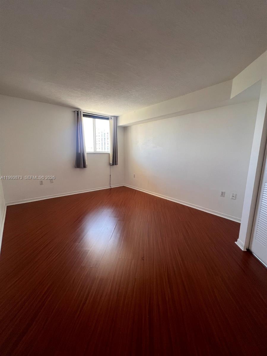 102 Southwest 6th Avenue, Unit 508 Miami, FL 33130 - Photo 21 of 27 an empty room with wooden floor and windows