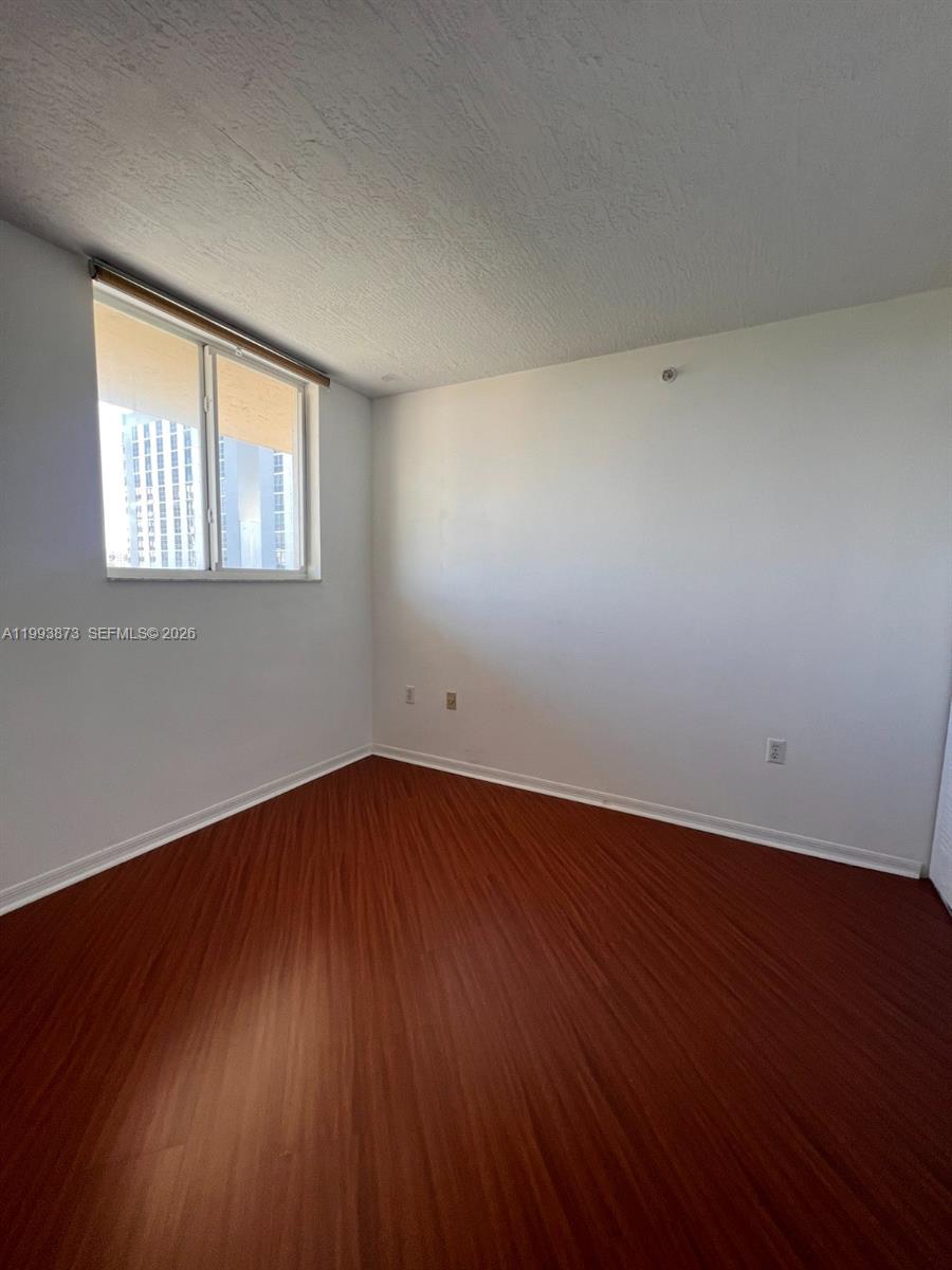 102 Southwest 6th Avenue, Unit 508 Miami, FL 33130 - Photo 23 of 27 an empty room with wooden floor and windows