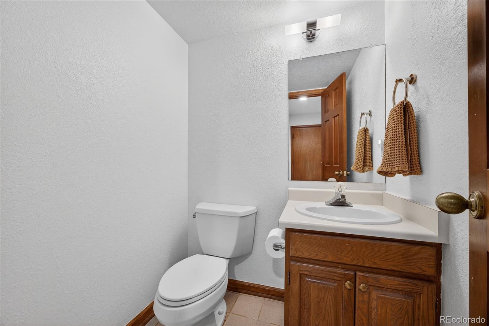 3200 Zephyr Court Wheat Ridge, CO 80033 - Photo 13 of 45 a bathroom with a toilet sink and mirror