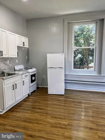 a kitchen with a white stove top oven and refrigerator