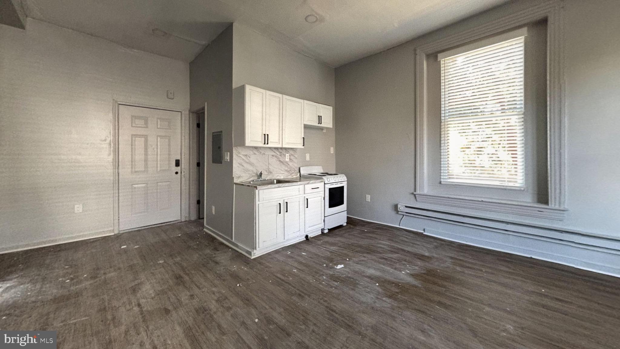 5003 Penn Street, Unit 1F Philadelphia, PA 19124 - Photo 4 of 11 a view of a kitchen with wooden floor and windows
