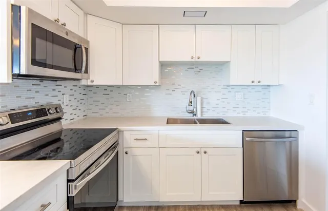 a kitchen with appliances a sink and cabinets