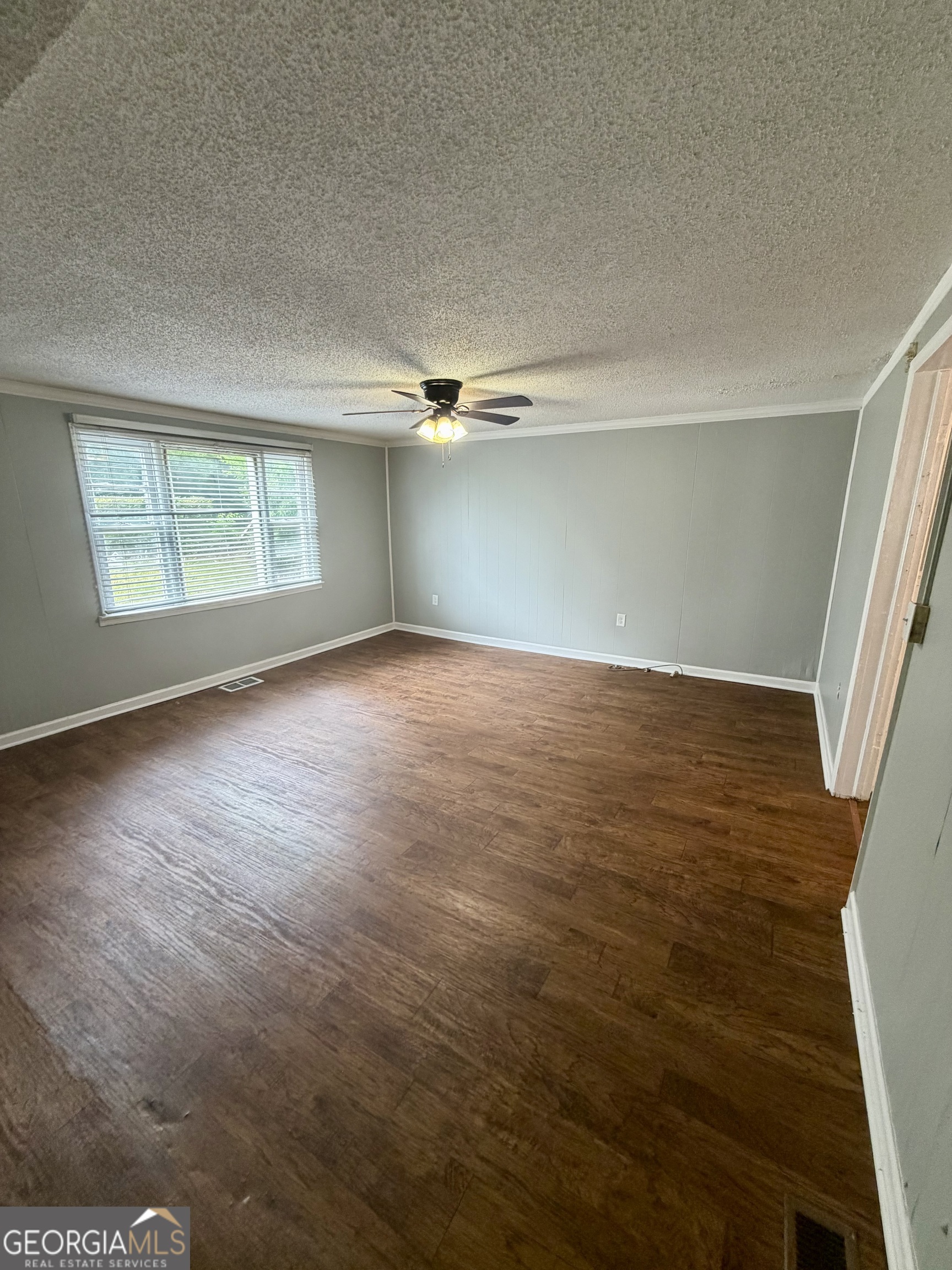 666 Woolfolk Street Macon, GA 31217 - Photo 8 of 60 an empty room with wooden floor cabinet and windows