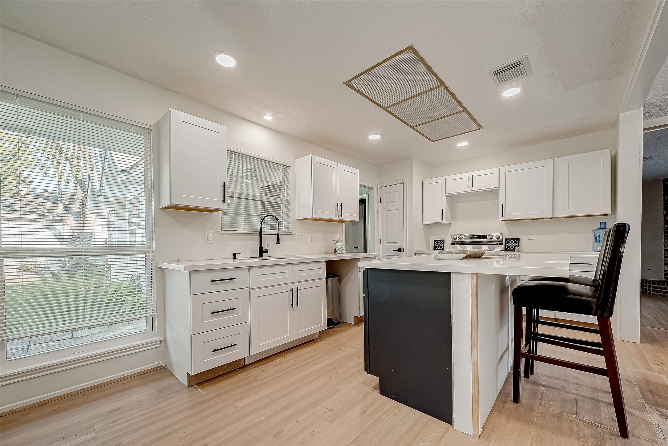 4731 Casemont Drive Spring, TX 77388 - Photo 14 of 50 a kitchen with stainless steel appliances kitchen island granite countertop a stove top oven a sink dishwasher a refrigerator and white cabinets with wooden floor