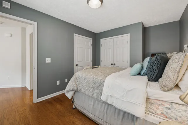 a bedroom with a bed and wooden floor