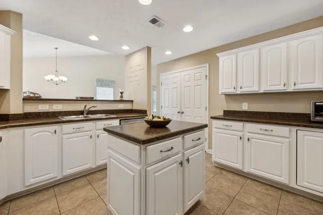 a kitchen with granite countertop white cabinets and white appliances