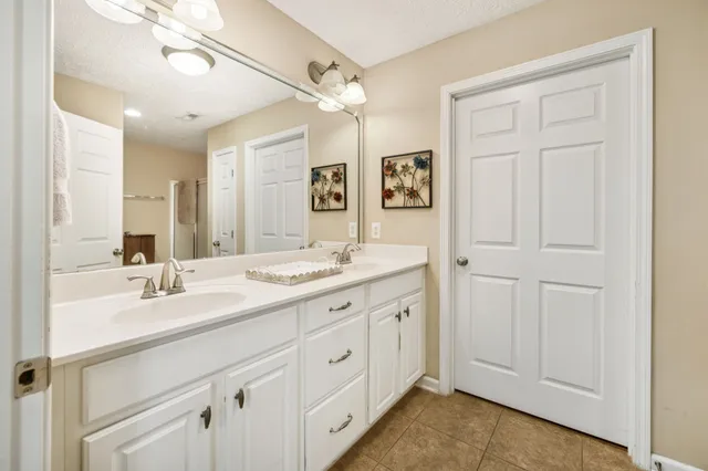 a spacious bathroom with a double vanity sink and a mirror