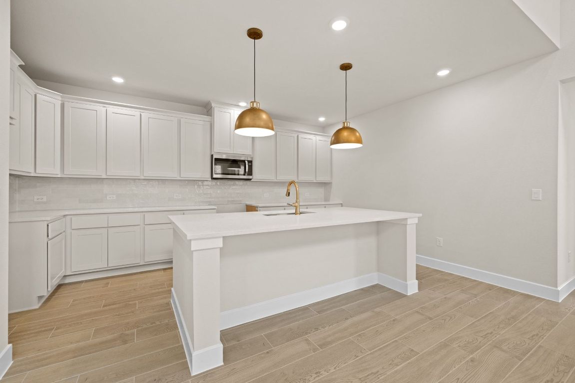 621 Buckaroo Drive Georgetown, TX 78633 - Photo 7 of 30 a kitchen with kitchen island a sink stainless steel appliances and cabinets