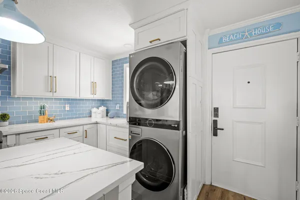a kitchen with stainless steel appliances kitchen island granite countertop a sink a stove and white cabinets