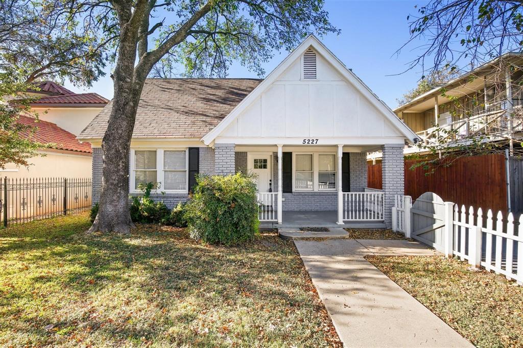 a view of a house with a small yard and wooden fence