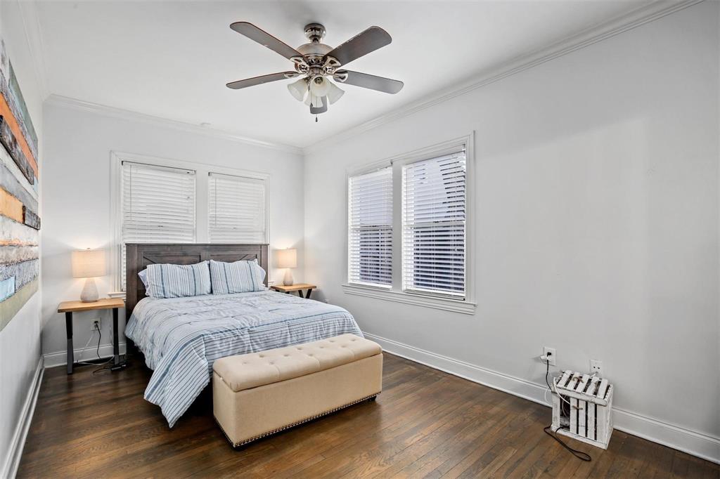 5227 Homer Street Dallas, TX 75206 - Photo 16 of 36 a spacious bedroom with a bed and a chandelier