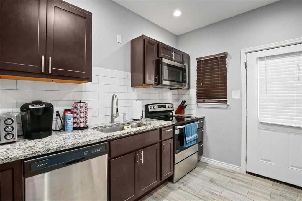 5227 Homer Street Dallas, TX 75206 - Photo 31 of 36 a kitchen with stainless steel appliances granite countertop a sink stove and microwave