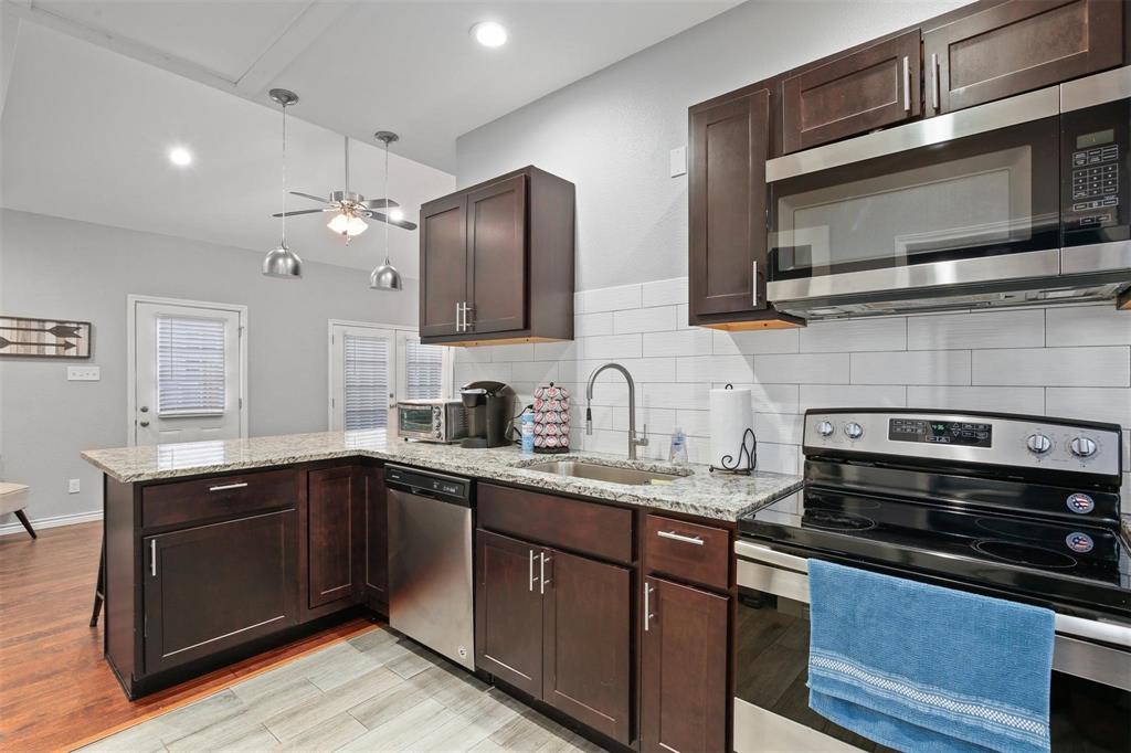 5227 Homer Street Dallas, TX 75206 - Photo 32 of 36 a kitchen with stainless steel appliances granite countertop a sink and stove top oven