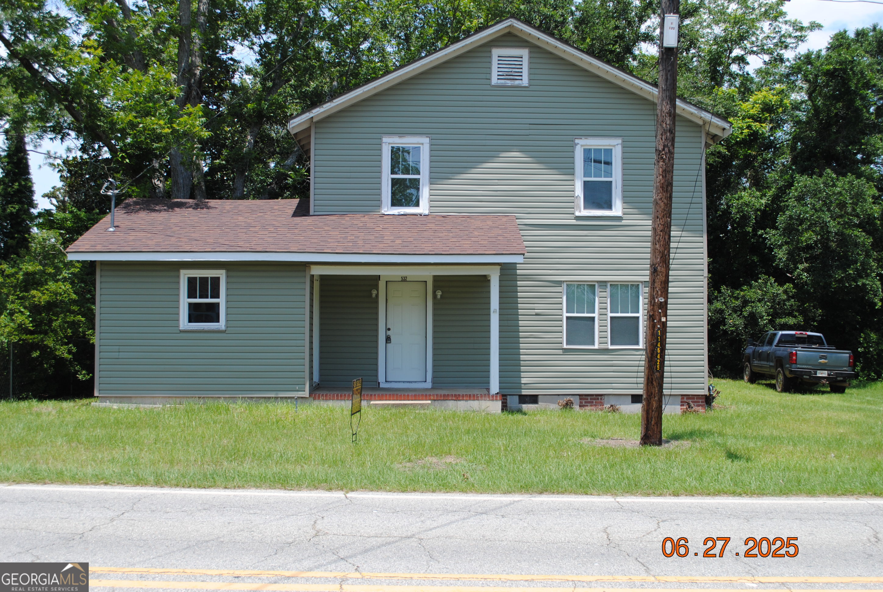 a front view of a house with a garden and yard