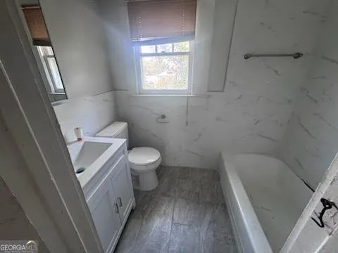a white toilet sitting next to a bath tub
