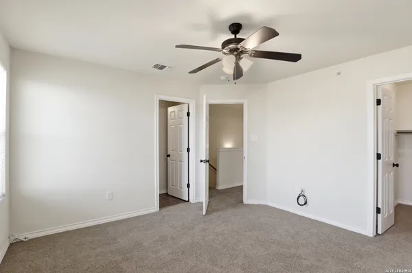 a view of a room with a ceiling fan and a fan
