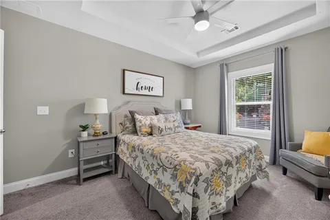 a bedroom with a bed painting on wall and a window