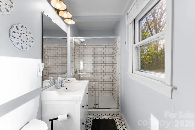 a bathroom with a sink a toilet and a window