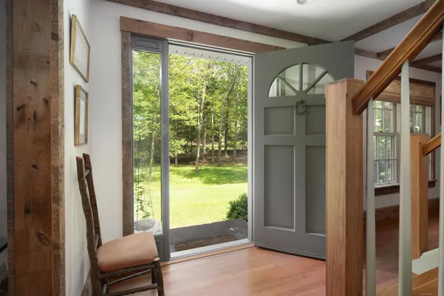 a view of a room with a large window and wooden floor
