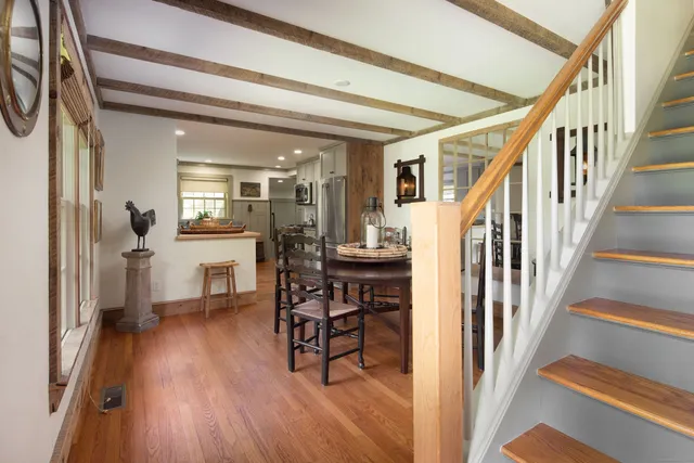 a view of a hallway with dining room and wooden floor