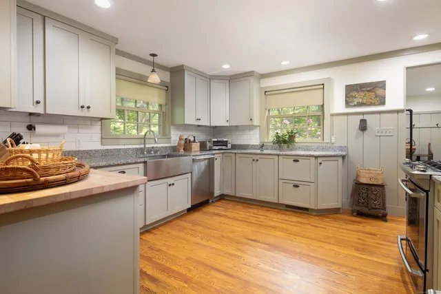 a kitchen with a sink window and cabinets