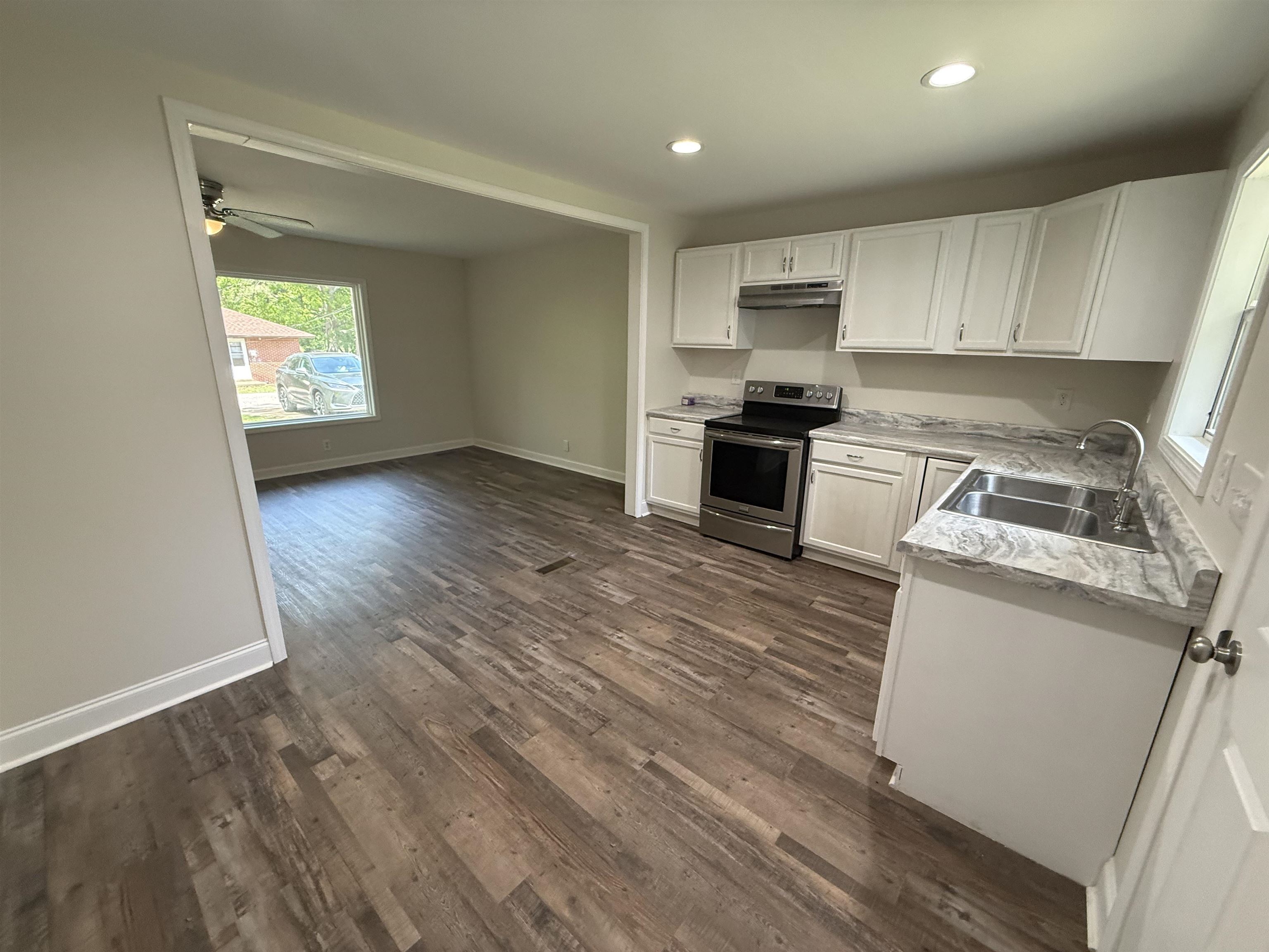 112 Tapp Drive Somerville, TN 38068 - Photo 6 of 16 a kitchen with granite countertop a stove top oven a sink dishwasher and a refrigerator with wooden floor