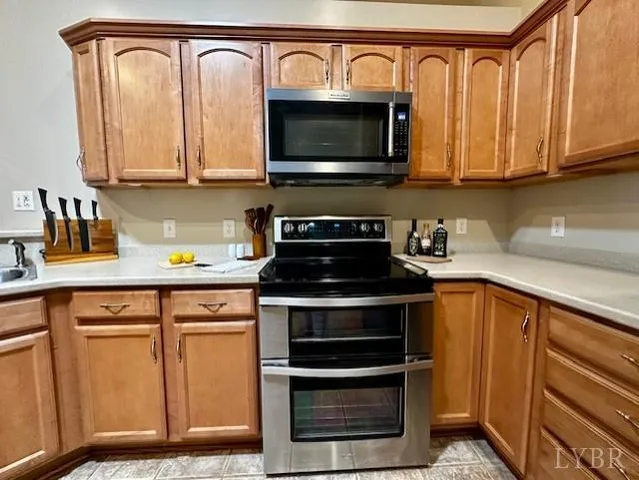 a kitchen with stainless steel appliances granite countertop a stove microwave and cabinets