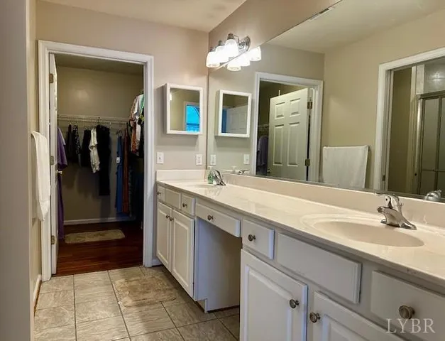 a spacious bathroom with a granite countertop sink a mirror and a shower