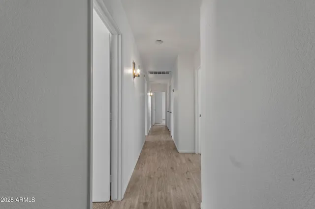 a view of a hallway with wooden floor