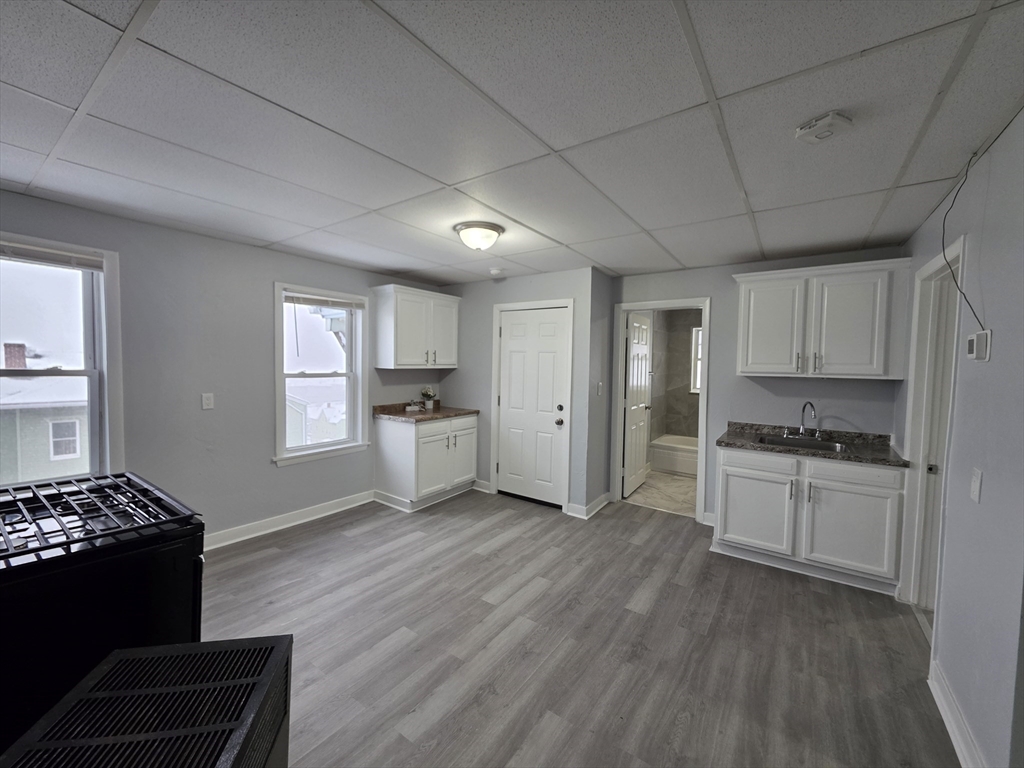 a kitchen with stainless steel appliances granite countertop a stove a sink dishwasher and a refrigerator with wooden floor