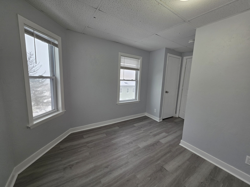 39 Harlem Street, Unit 3 Worcester, MA 01610 - Photo 12 of 18 an empty room with wooden floor and windows