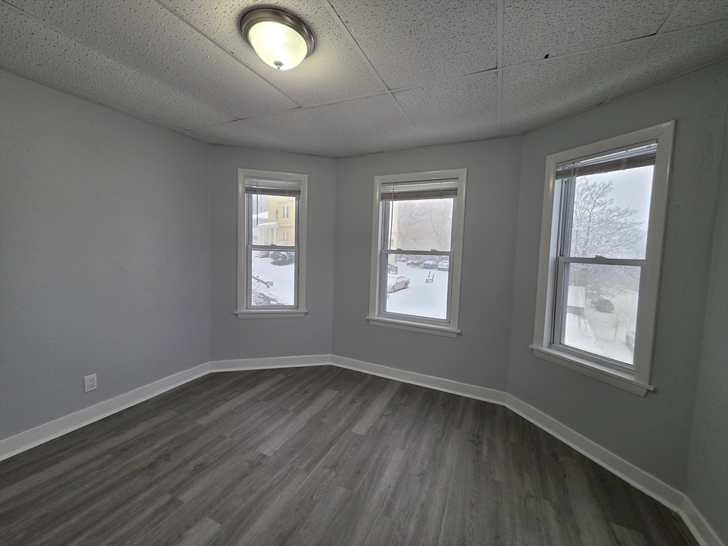39 Harlem Street, Unit 3 Worcester, MA 01610 - Photo 13 of 18 a view of an empty room with wooden floor and a window