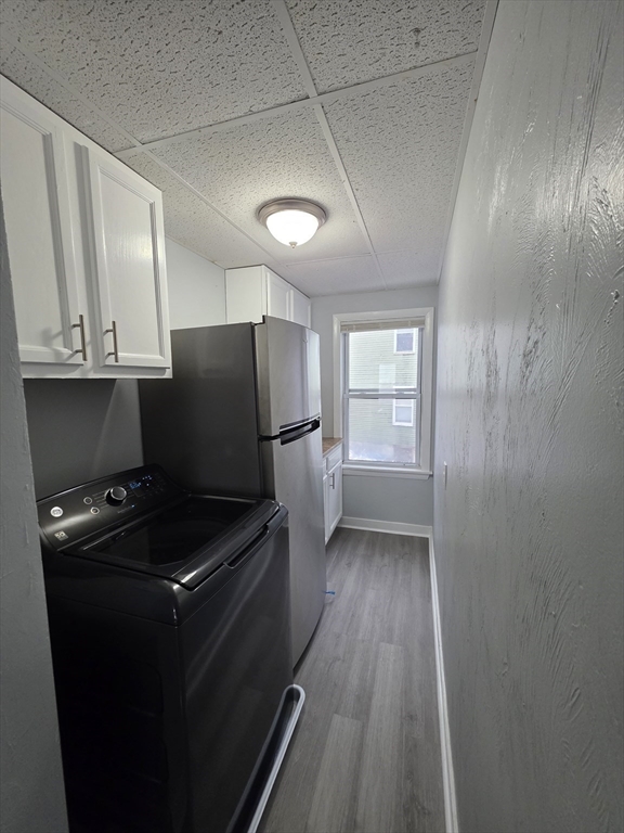 39 Harlem Street, Unit 3 Worcester, MA 01610 - Photo 4 of 18 a kitchen with granite countertop a refrigerator a sink and wooden floors