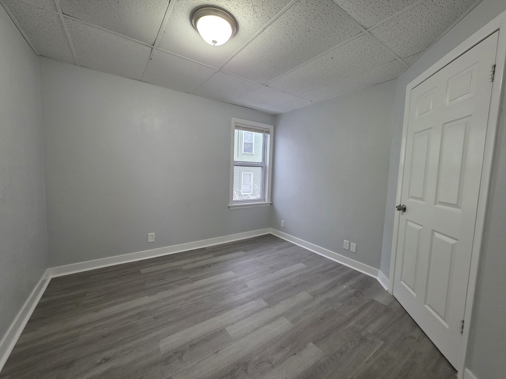 39 Harlem Street, Unit 3 Worcester, MA 01610 - Photo 9 of 18 an empty room with wooden floor and windows