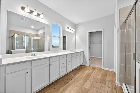 a spacious bathroom with a double vanity sink and mirror
