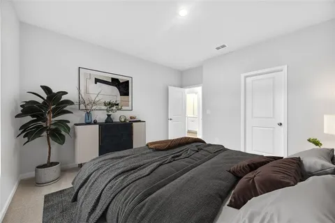 a bedroom with a bed and a potted plant