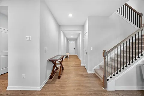 a view of a hallway with the wooden floor and staircase