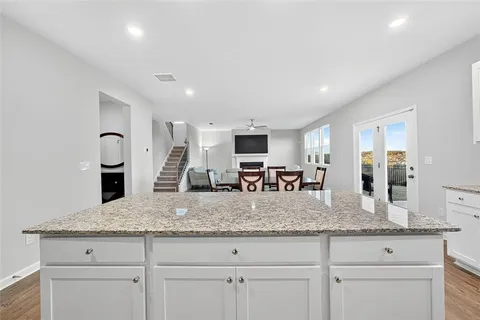 a kitchen with granite countertop stainless steel appliances sink stove and granite counter top