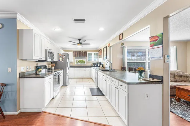 a large kitchen with stainless steel appliances kitchen island granite countertop a large counter top and a stove