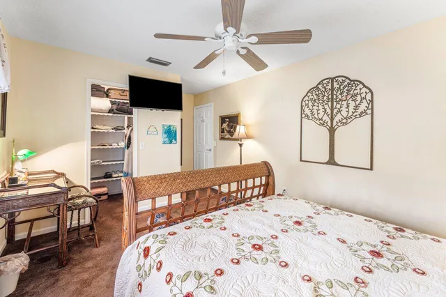 a bedroom with a bed a dresser with wooden floor