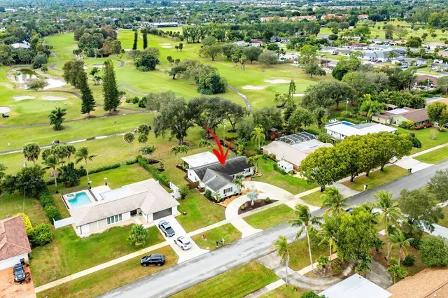 an aerial view of residential houses with outdoor space and swimming pool