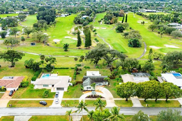 an aerial view of residential houses with outdoor space and lake view